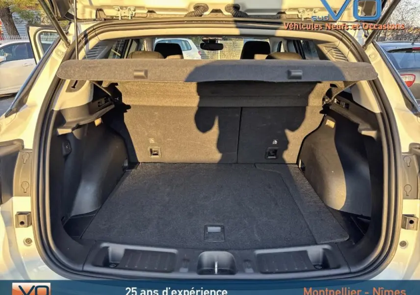 Coffre ouvert vu de l'arrière du Jeep Compass blanc 2023, montrant un espace de chargement propre et spacieux.