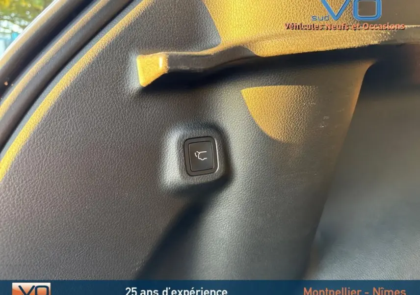Bouton d'ouverture électrique du coffre sur le panneau intérieur arrière d'un Jeep Compass blanc 2023.