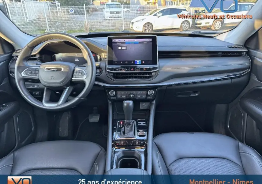 Intérieur noir du Jeep Compass 2023 vu de face, avec tableau de bord moderne et écran tactile central.