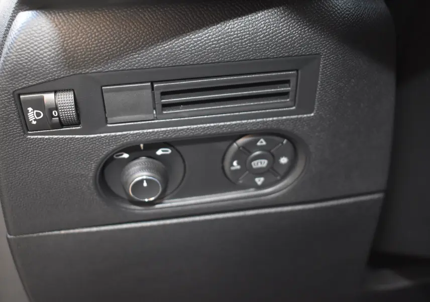 Détail intérieur du tableau de bord côté gauche du DS3 Crossback 2024, avec commandes d'éclairage et réglages des rétroviseurs.