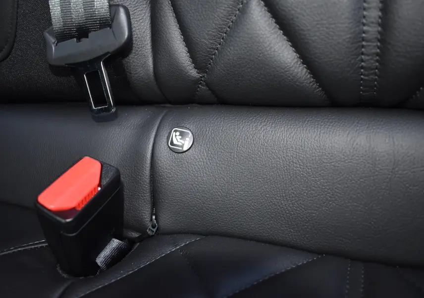 Gros plan sur la ceinture de sécurité et l'icône ISOFIX sur la banquette arrière en cuir noir du DS3 Crossback 2024.