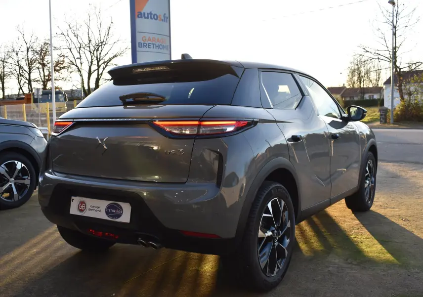 Vue 3/4 arrière droite d'un DS3 Crossback gris métallisé 2024 avec feux LED et jantes alliage distinctives.