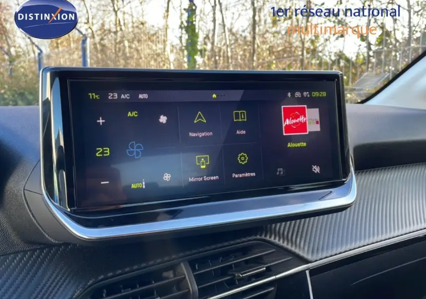 Écran tactile central affichant la climatisation et la navigation dans l'habitacle gris-noir d'une Peugeot 208 hybride.