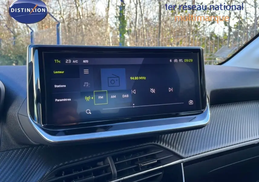 Écran tactile central de la Peugeot 208 noire 2025, vue intérieure du tableau de bord avec affichage radio FM.