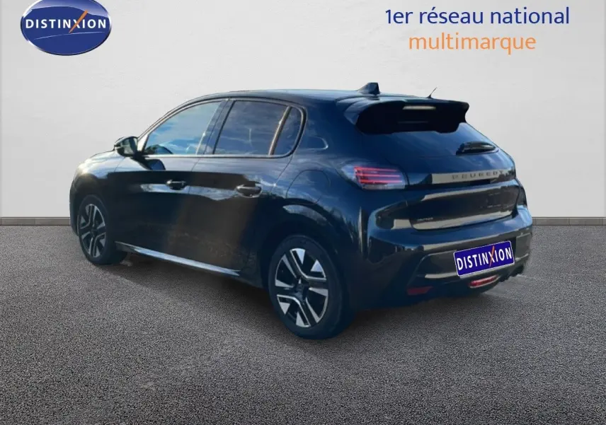Vue 3/4 arrière droite d'une Peugeot 208 noire 2025 hybride avec jantes distinctives et toit spoiler.