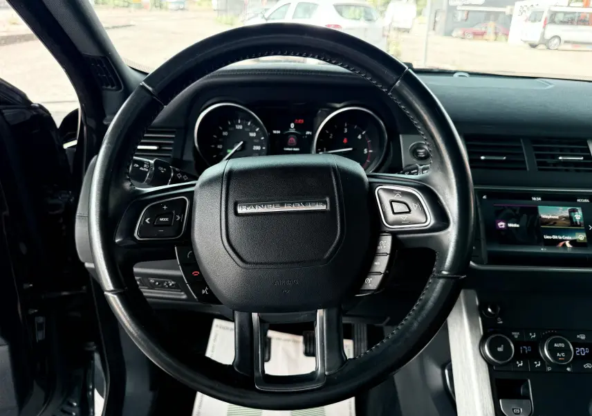 Volant noir de Range Rover Evoque 2017 vu de face avec tableau de bord et écran tactile en arrière-plan