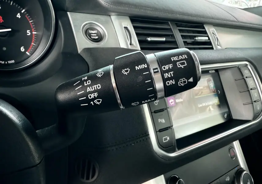 Gros plan sur la commande des essuie-glaces et l'écran tactile du tableau de bord noir du Range Rover Evoque 2017.