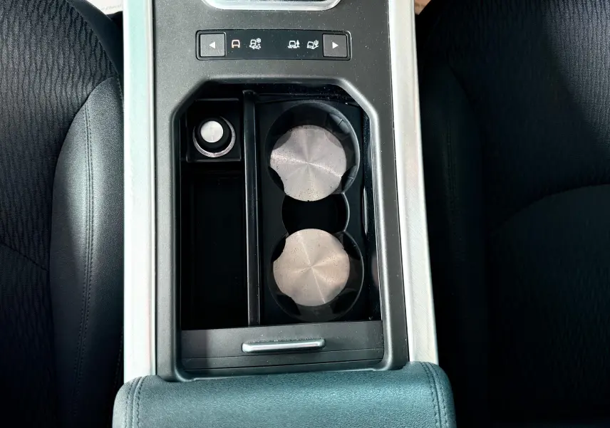 Vue plongeante sur la console centrale noire du Range Rover Evoque 2017, avec porte-gobelets et commandes de modes de conduite.