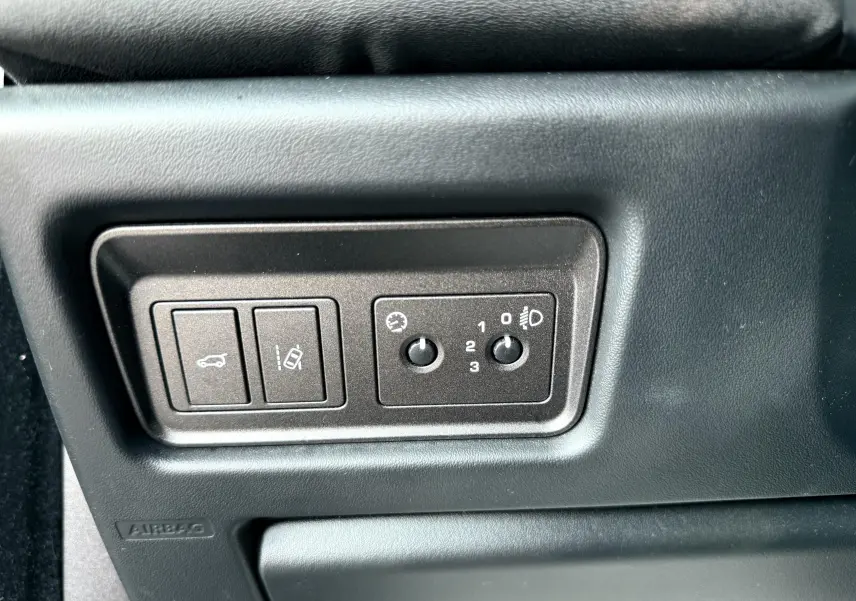 Panneau de commandes noir côté conducteur du Range Rover Evoque 2017 avec réglages des phares et ouverture du coffre.