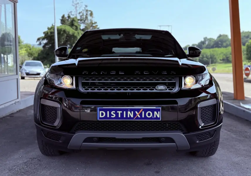 Vue frontale d'un Range Rover Evoque noir avec phares allumés et plaque d'immatriculation Distinxion visible.