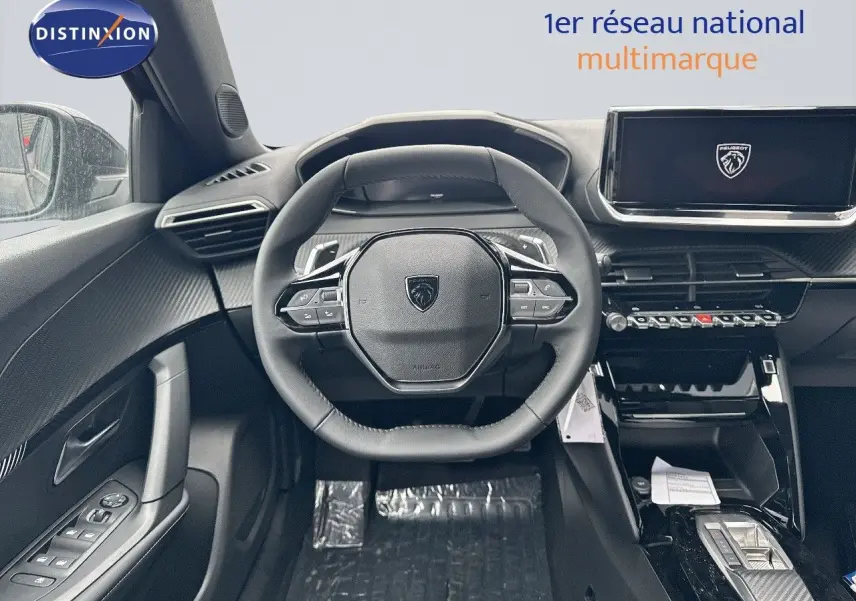 Intérieur du Peugeot 2008 Hybrid 2025, vue centrée sur le volant cuir noir et l'écran tactile moderne.