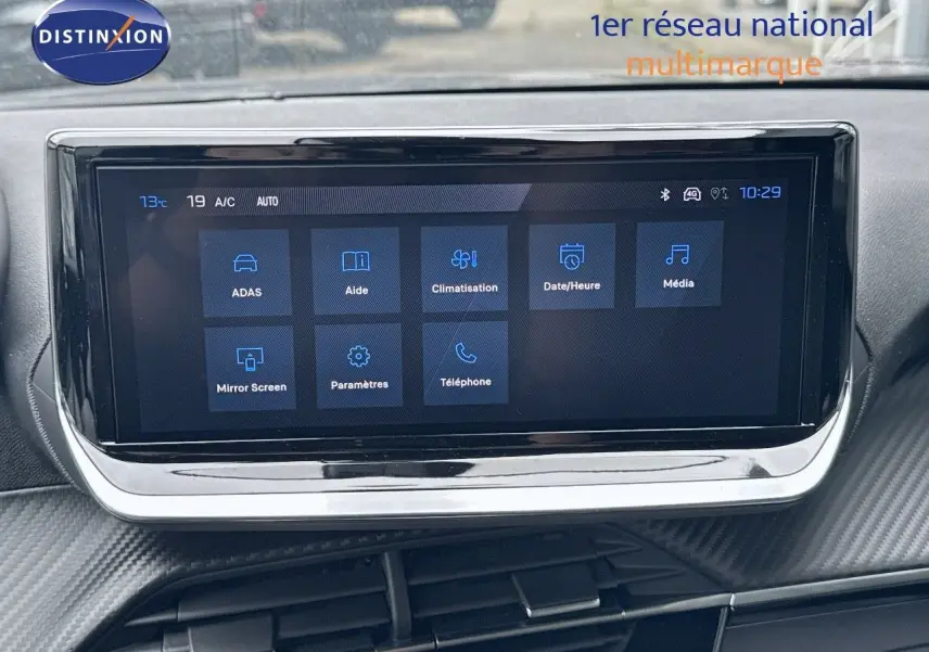 Écran tactile central affichant les options de climatisation et multimédia dans le tableau de bord d'un Peugeot 2008 noir métal.