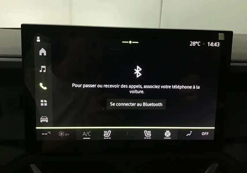Écran tactile central du Dacia Duster 2025 affichant la connexion Bluetooth avec commandes climatisation et sièges chauffants visibles.