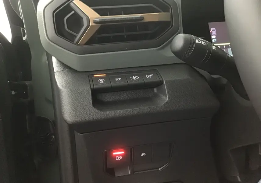 Détail du tableau de bord côté gauche du Dacia Duster kaki, avec commandes ECO et indicateur GPL allumé.