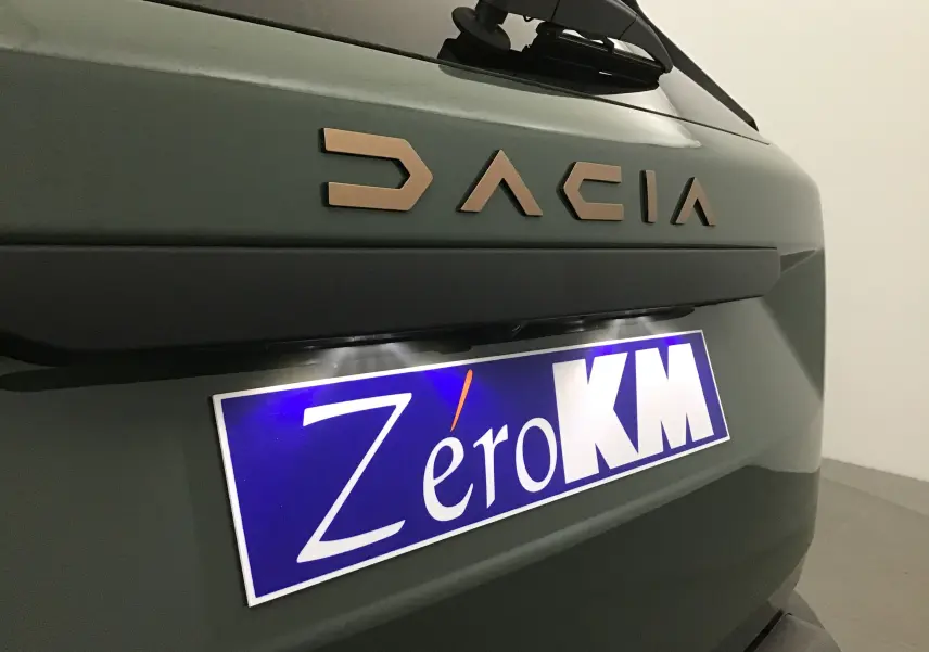 Gros plan sur l'arrière kaki lichen du Dacia Duster 2025 avec logo DACIA et plaque Zéro KM visible.