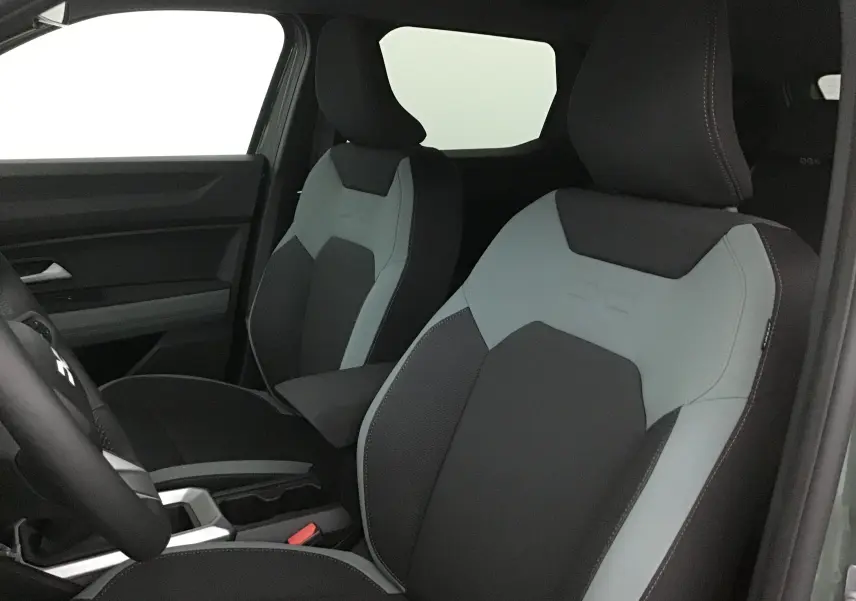 Vue intérieure rapprochée des sièges avant noirs et gris du Dacia Duster 2025 avec surpiqûres contrastées.