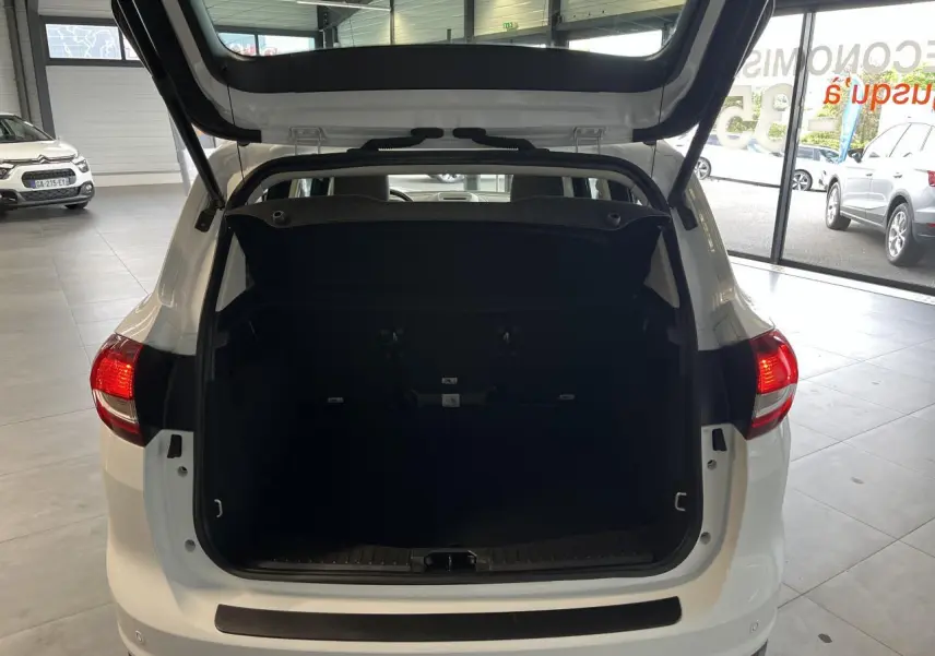 Vue arrière ouverte du coffre d'un Ford C-MAX blanc 2018 en intérieur, montrant l'espace de chargement vide.