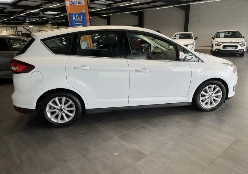 Ford C-MAX blanc vu de profil côté gauche dans un showroom avec jantes alliage 16 pouces.