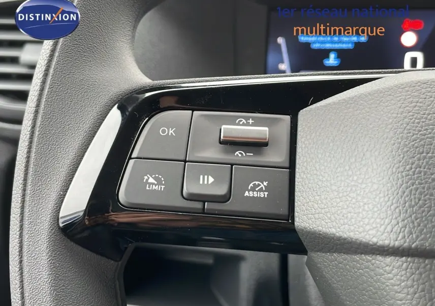 Gros plan sur les commandes au volant côté gauche du Peugeot Expert Fourgon blanc 2025 avec régulateur et limiteur de vitesse.