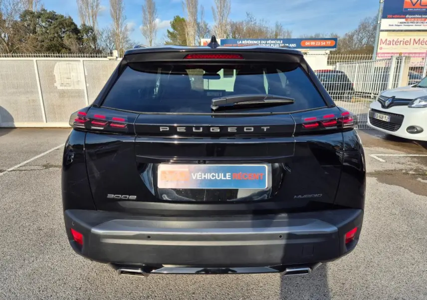 Vue arrière d’un Peugeot 2008 Hybrid 145 e-DCS6 GT noir, avec feux LED et double sortie d’échappement visible.