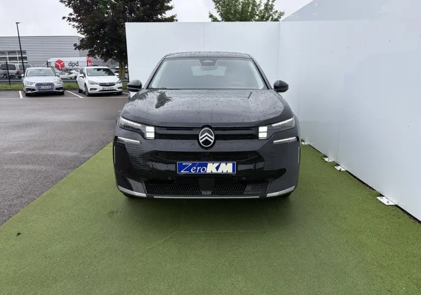 Vue avant d'un Citroën C5 Aircross noir métal avec feux LED distinctifs et logo centré sous la pluie.