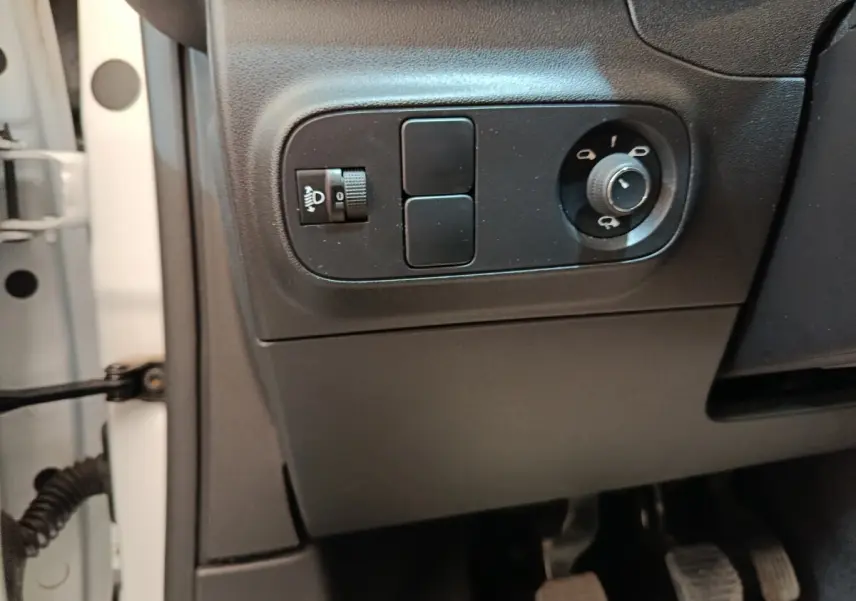 Vue intérieure côté gauche du tableau de bord d'une Citroën C3 blanche, avec commandes des phares et rétroviseurs.