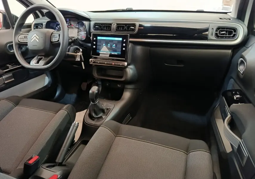 Vue intérieure avant droite du Citroën C3 blanc 2020, montrant le tableau de bord avec écran tactile et volant multifonctions.