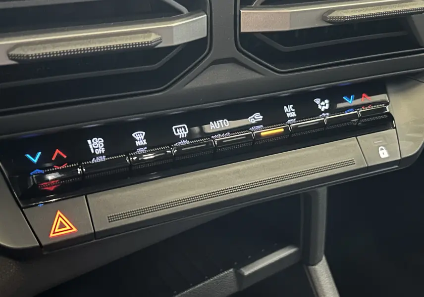 Gros plan sur la console centrale de la Dacia Bigster 2026, montrant les commandes tactiles de climatisation et le bouton de verrouillage.