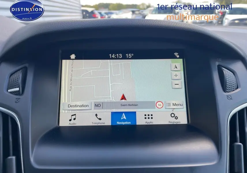 Écran tactile du système de navigation Ford SYNC dans une Ford Focus SW gris magnetic, vue frontale intérieure.