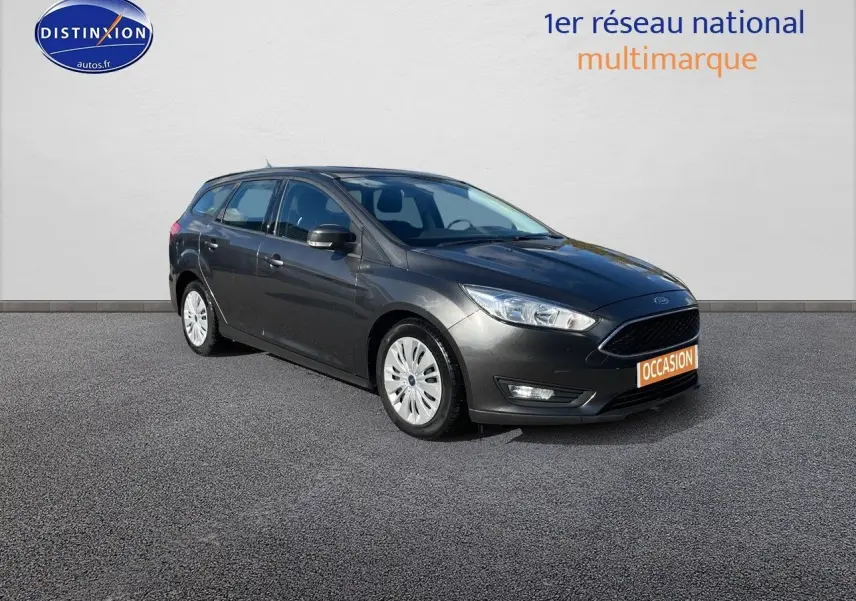 Ford Focus SW gris magnetic metal vue 3/4 avant droit sur fond neutre avec plaque occasion orange visible