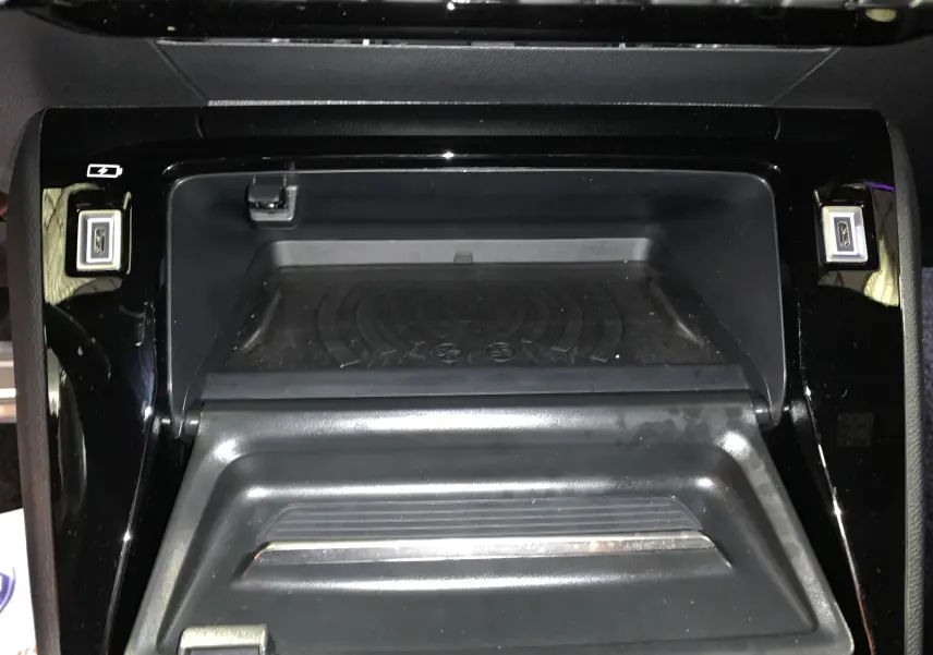 Rangement central ouvert avec plateau de recharge sans fil et ports USB dans le Peugeot 2008 gris 2023.