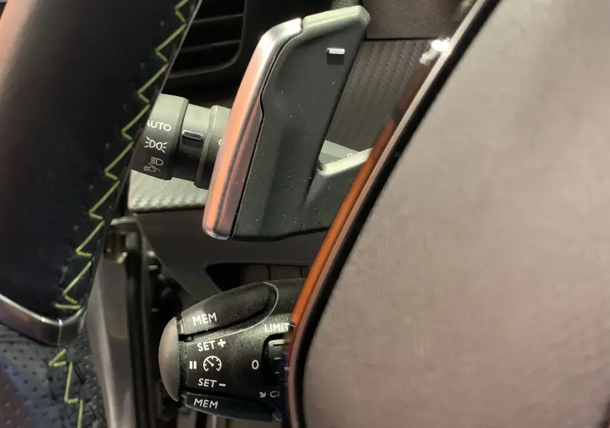 Gros plan sur la commande de régulateur de vitesse au volant du Peugeot 2008 gris 2023, finition GT.