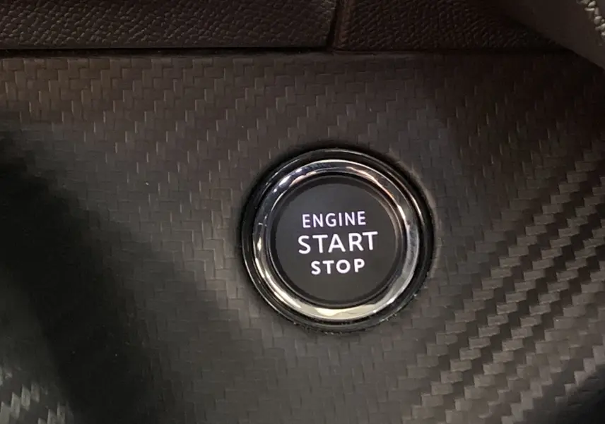 Bouton start/stop moteur sur tableau de bord en carbone du Peugeot 2008 BlueHDi 130 GT gris 2023.