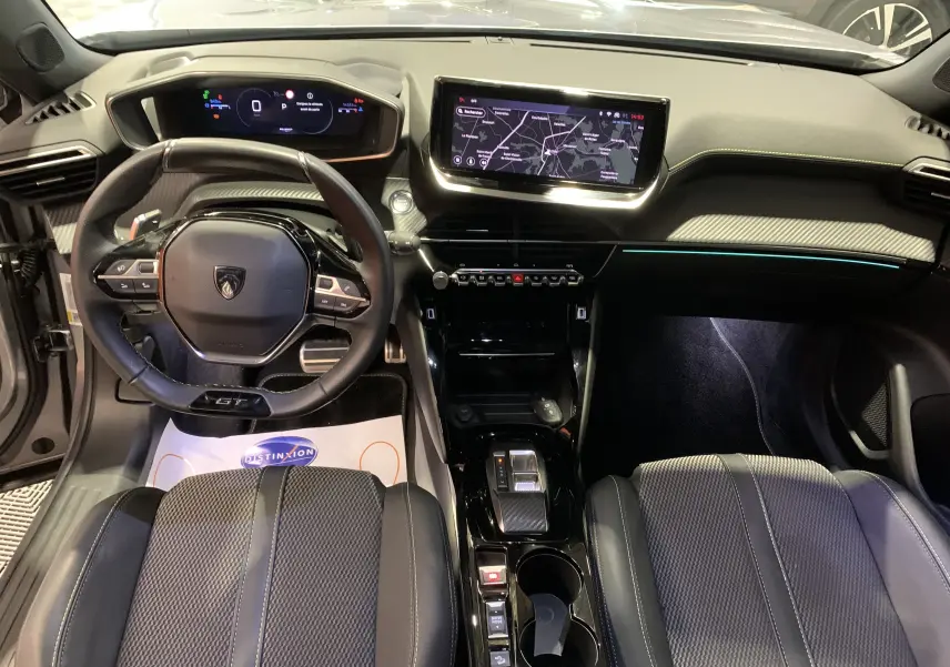 Vue intérieure avant du Peugeot 2008 GT 2023 gris, avec tableau de bord numérique et écran tactile central lumineux.
