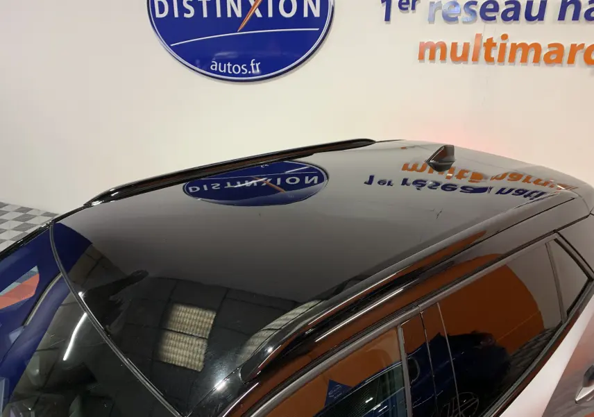 Toit panoramique noir brillant du Peugeot 2008 gris, vu en plongée depuis l'avant droit, avec antenne requin.