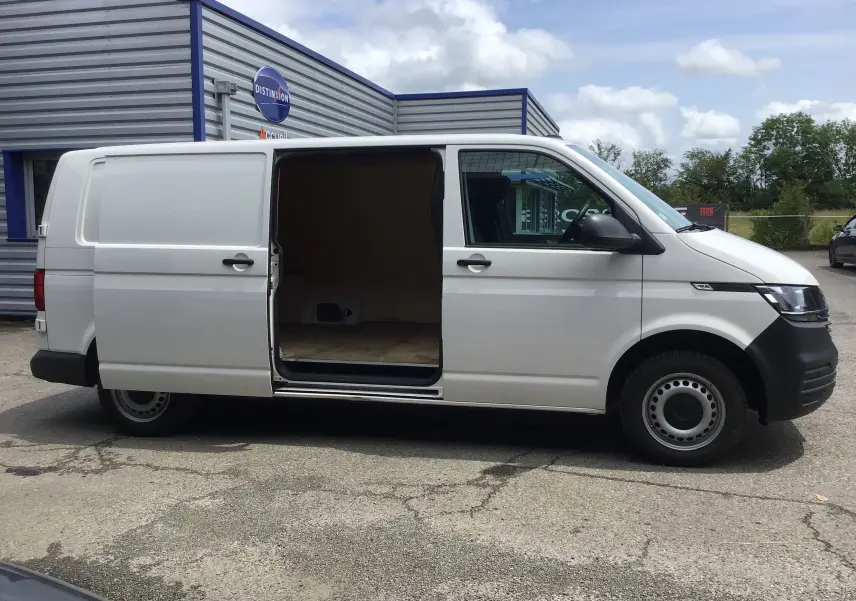 Vue latérale droite d'un Volkswagen Transporter 6.1 blanc avec porte coulissante ouverte montrant l'espace de chargement vide.
