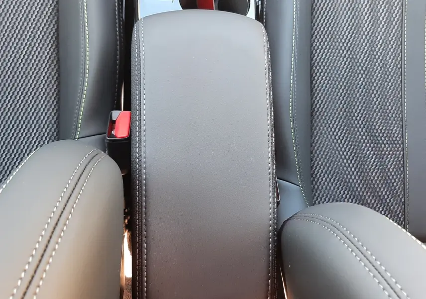 Accoudoir central en cuir noir avec surpiqûres blanches entre les sièges avant du Peugeot 2008 gris Selenium 2025.