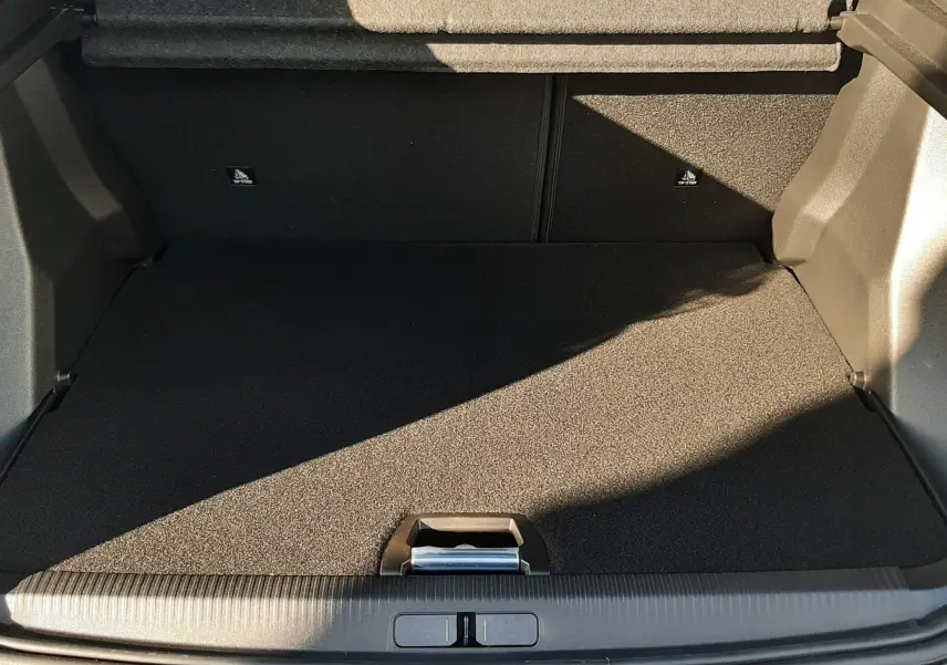 Coffre ouvert vu de l'arrière d'un Peugeot 2008 gris Selenium, montrant un espace de chargement propre et vide.