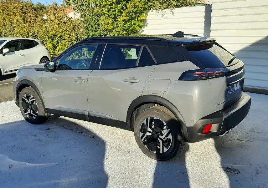 Peugeot 2008 1.2 Hybrid 145ch GT gris selenium vue de profil côté gauche, toit noir et jantes bi-ton.