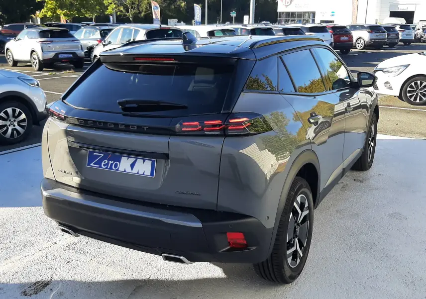 Peugeot 2008 1.2 Hybrid 145ch GT gris selenium vue 3/4 arrière droit avec toit noir et feux LED distinctifs.