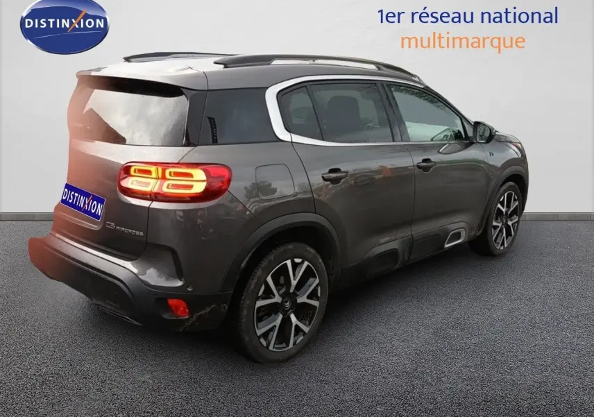 Vue 3/4 arrière droite du Citroën C5 Aircross hybride rechargeable 2022 en gris platinium avec jantes distinctives.