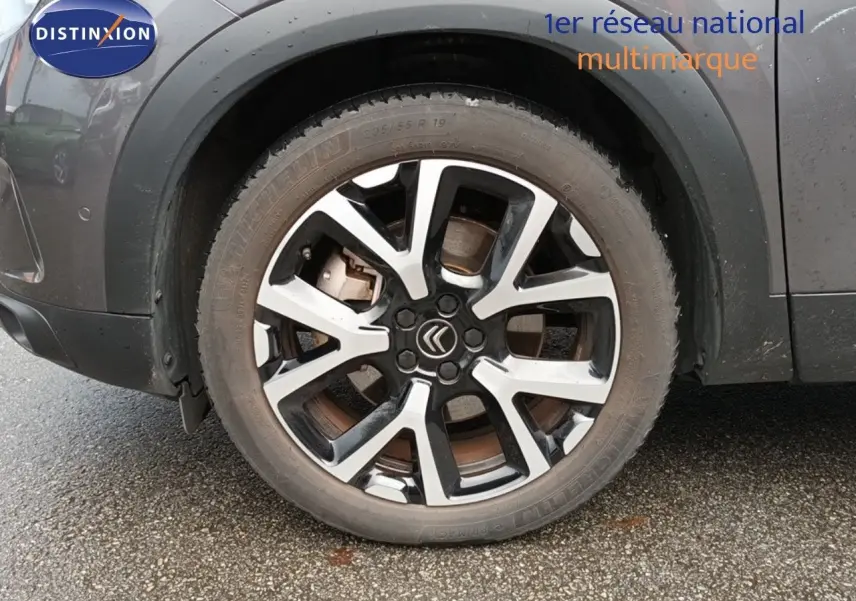 Gros plan sur la roue avant gauche d’un Citroën C5 Aircross gris platinium avec jante alliage bicolore.