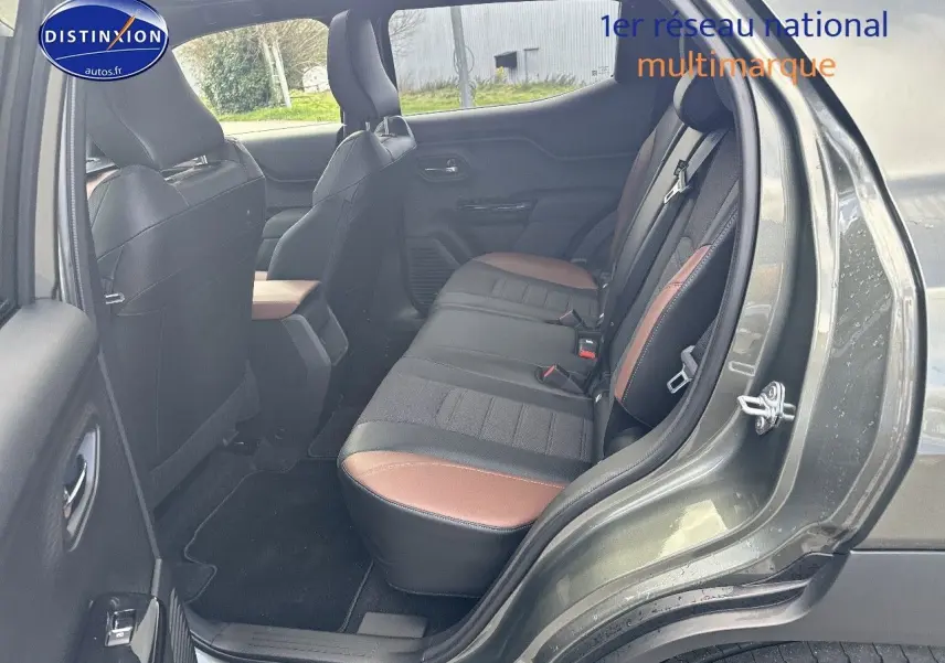 Vue côté gauche arrière du Suzuki Vitara 2026 vert Land Breeze avec intérieur cuir noir et marron visible.