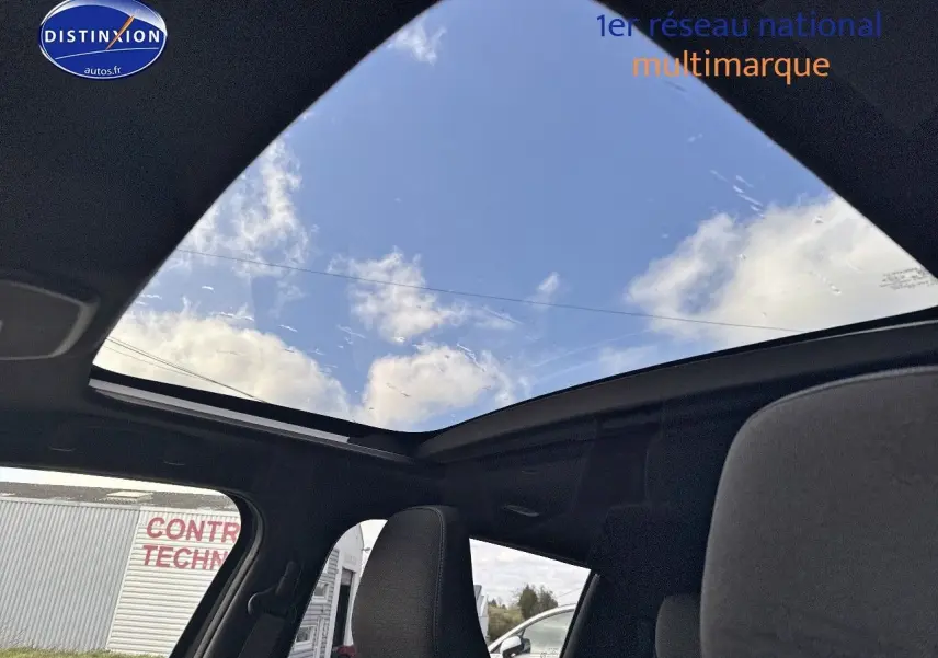 Vue intérieure du toit panoramique en verre du Suzuki Vitara 2026, avec ciel bleu visible à travers la vitre ouverte.