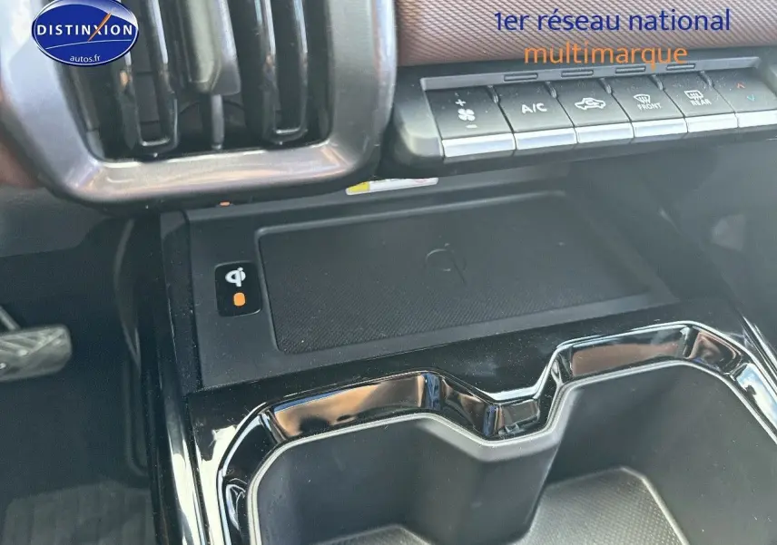 Gros plan sur la console centrale du Suzuki Vitara 2026 avec chargeur sans fil et commandes climatisation.