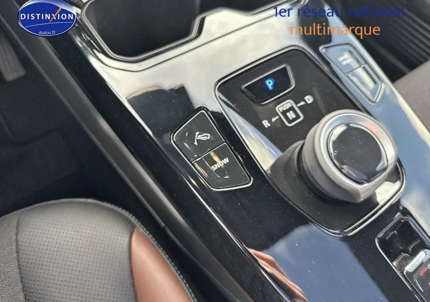 Gros plan sur la console centrale noire brillante du Suzuki Vitara 2026, avec molette de boîte auto et siège cuir noir/marron visible.