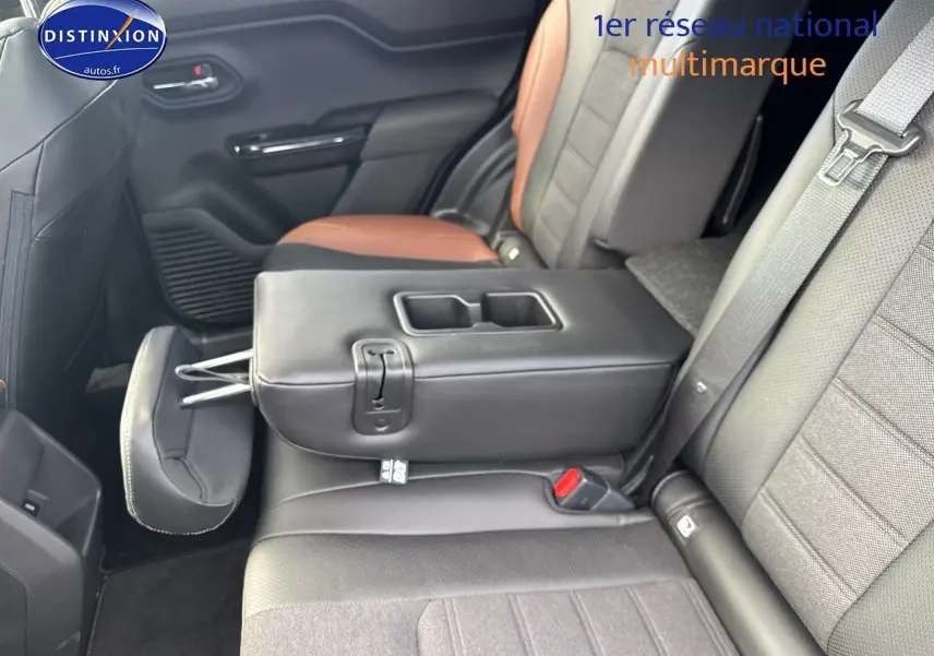 Vue intérieure arrière du Suzuki Vitara 2026, montrant la banquette bicolore noire et marron avec accoudoir central relevé.