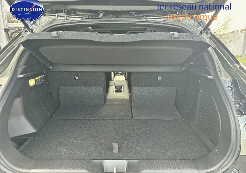 Coffre ouvert du Suzuki Vitara 2026 vert Land Breeze avec toit noir, montrant banquette arrière rabattue et espace de chargement.