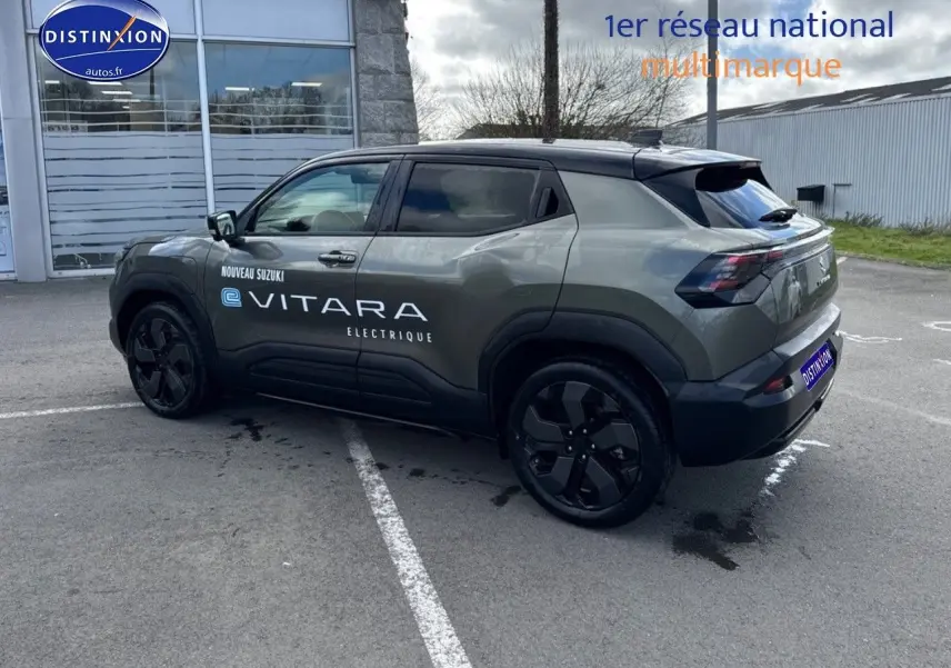 Suzuki Vitara électrique 2026 vert Land Breeze avec toit noir, vue 3/4 arrière côté gauche, jantes noires.