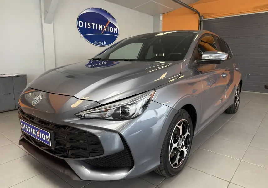 MG3 1.5 L Hybrid+ gris Hampstead en 3/4 avant droit, avec jantes bi-ton et calandre noire brillante.